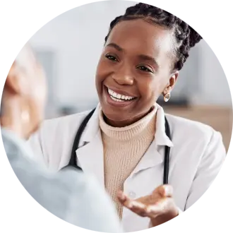 A smiling healthcare professional engages warmly with a patient during a consultation, showcasing a friendly and supportive atmosphere.