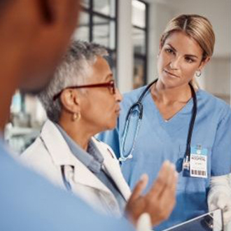 A smiling healthcare professional engages warmly with a patient during a consultation, showcasing a friendly and supportive atmosphere.
